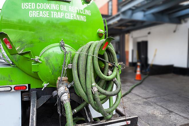 large truck pumping grease trap at a restaurant in Cooper City